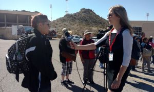Chloe Nordquist interviews an attendee at the University of Texas at El Paso Sun Bowl before the livestream of Pope Francis' Mass in Ciudad Juárez. (Photo by Molly Bilker/Cronkite News)