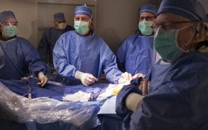 Cardiologist Timothy Byrne and his team look into the monitor while preforming heart surgery. (Photo by Brian Thorsen/TAVR Abrazo Arizona Heart Hospital)