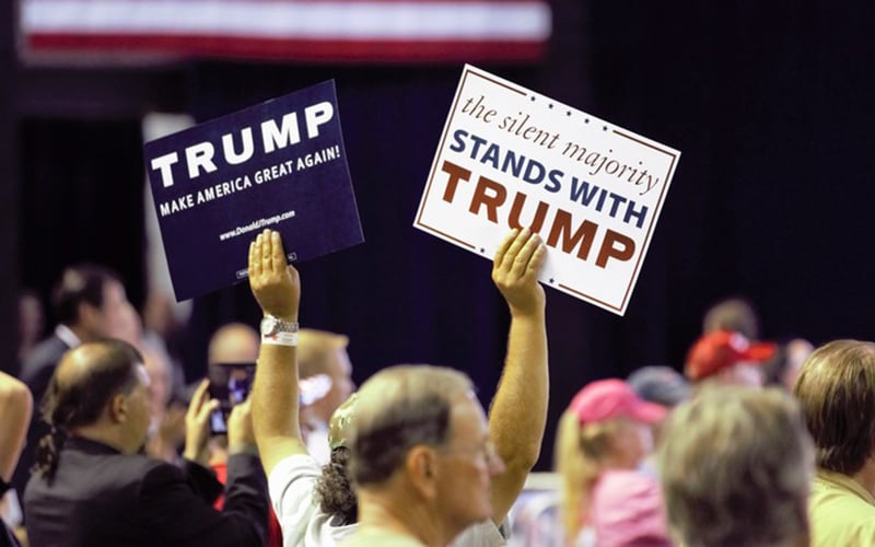 Trump supporters wave signs during his June 18 rally. (Photo by Selena Makrides/Cronkite News)