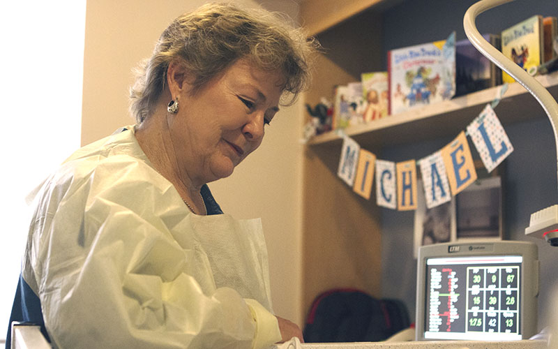 Diane Minton looks over her grandson at the Phoenix Children's Hospital. (Photo by Christopher West/Cronkite News)
