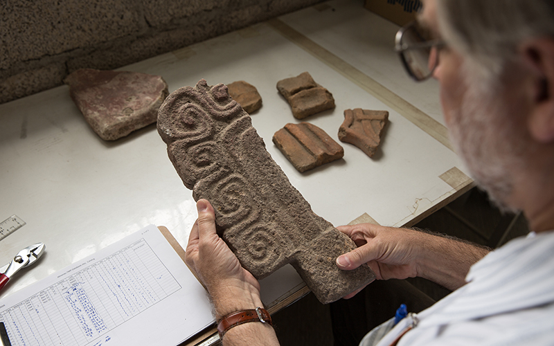 Professor Mike Smith looks at part of an Almena at the ASU Teotihuacan Research Laboratory. (Photo by Ken Fagan/ASU Now)