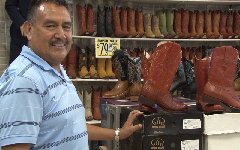 Abel Serrano, a clerk at clothing store in Phoenix, urges people in the Latino community to exercise their right to vote.  (Photo by Lillian Griego/Cronkite News)