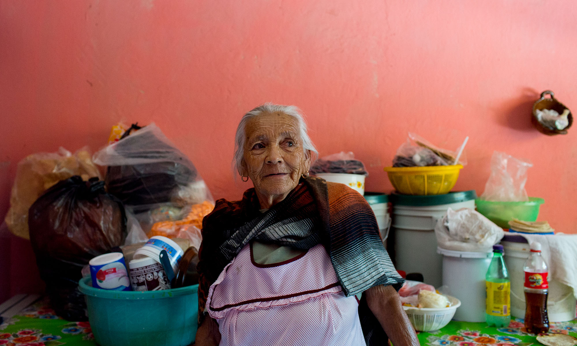 Rojas in her kitchen. She does no longer works and she and her husband rely heavily on remittances from their children, in addition to a little government support. Her children crossed the border in the 1980s, became legal, documented immigrants during the Reagan administration and are now U.S. citizens with their own American grandchildren. Rojas has about 15 grandchildren and great-grandchildren who are U.S. citizens, including one who did military service. Because the family can cross the border legally, they are able to visit and were home at Christmas, but Rojas wishes she could see them more. “One day I’m going to die, one day, and I’m not going to see my children anymore,” Rojas said. (Photo by Courtney Pedroza/Cronkite Borderlands Initiative)