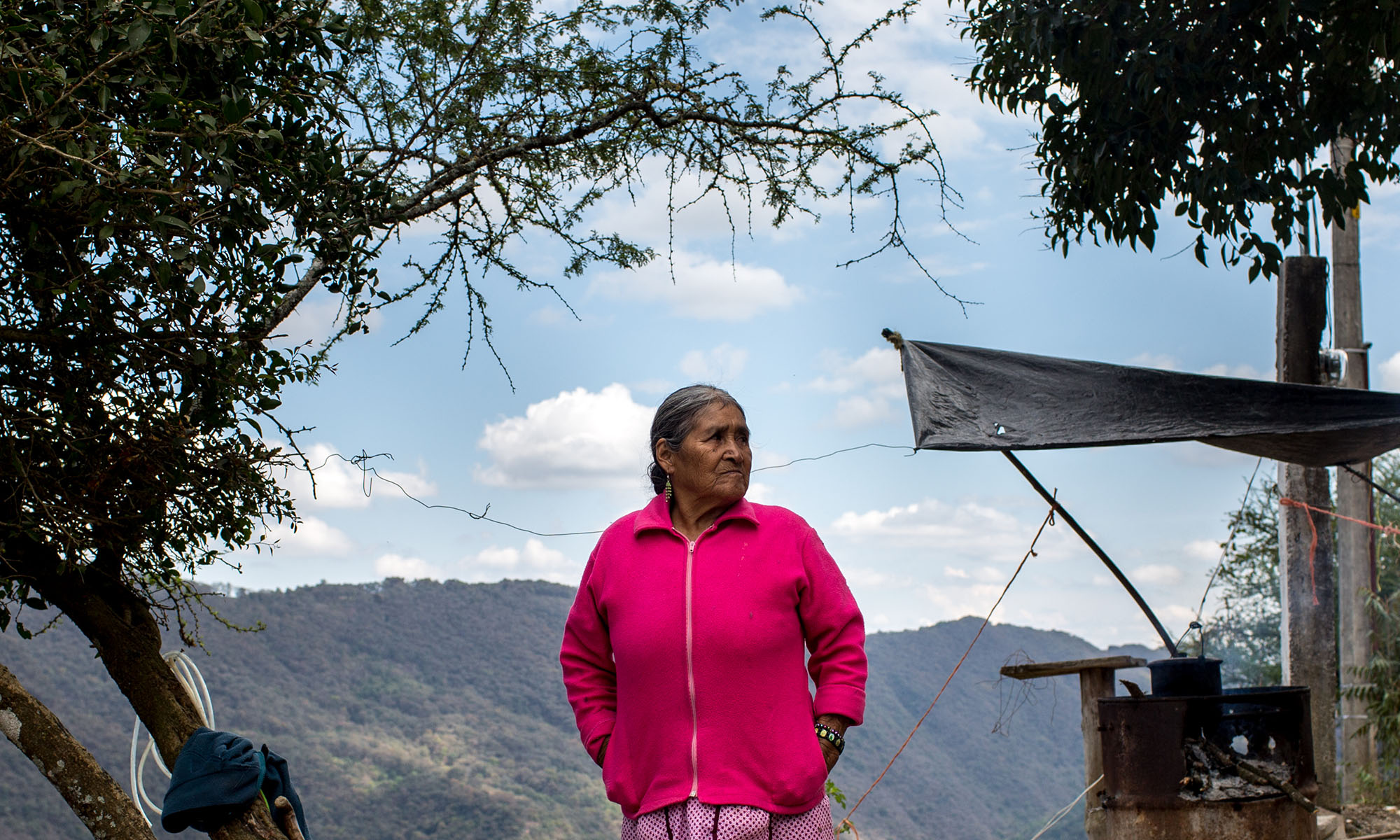 Mendoza stands by the stove outside her home overlooking the Sierra Gorda Biosphere Reserve. Her granddaughter, who she has not seen in 15 years, sends her money from the U.S. where she now has five grandchildren. She worries about them since Trump’s election and his statements on undocumented immigrants and remittances. “Only God can watch over them. We are waiting to see if they will be deported. Right now they aren’t safe over there, the poor things,” she said. (Photo by Courtney Pedroza/Cronkite Borderlands Initiative)