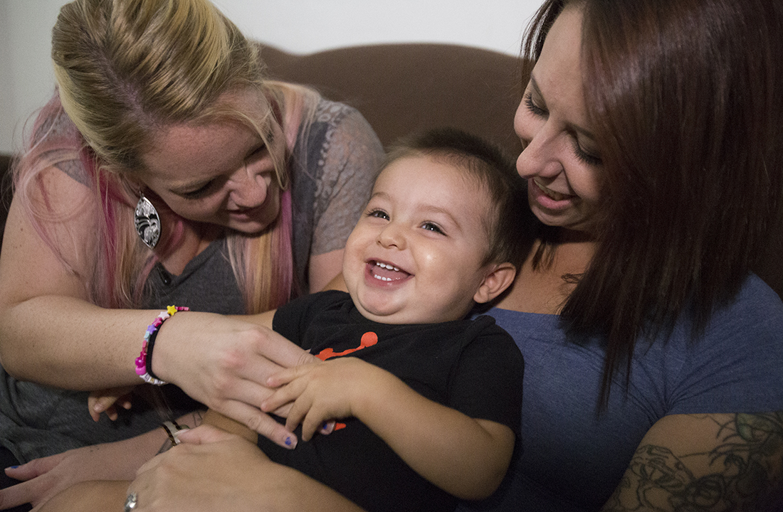 Carissa Denny (left) and Kyla Wall hold Jayden at Sally’s Place in Phoenix, a residential housing program that puts an emphasis on long-term treatment that goes beyond detoxing and 30 days of sobriety. (Photo by Johanna Huckeba/Cronkite News)