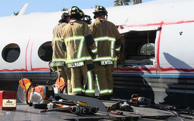 Mesa firefighers used a saw and other tools to cut makeshift emergency exits in a jet. (Photo by Alyssa Hesketh/Cronkite News)