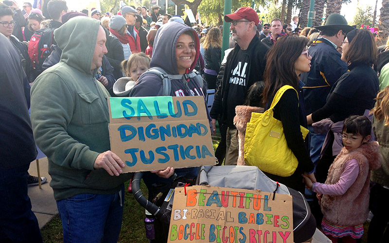 Gloria Montaño, 38, and Seean Greene, 45, celebrate their biracial family at the Phoenix women's march. (Photo by Saundra Wilson/Cronkite News)