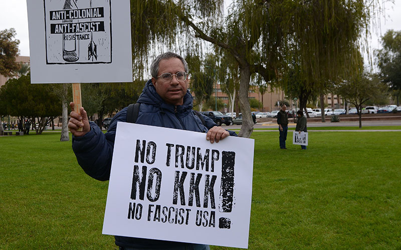 Phoenix resident Randy Dinin, 53, stands in front of the Arizona State Capitol on Friday, Jan. 20, 2017, in protest of President Donald Trump's inauguration. Dinin's signs read 