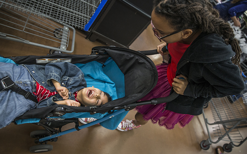 Kenyah, one of the 15-year-old triplets, plays with Zealynd during a shopping trip to Walmart on Sunday, Feb. 14, 2017. The weekends are a time for family outings, including church every Sunday and frequent visits to the Phoenix Zoo. (Photo by Johanna Huckeba/Cronkite News)