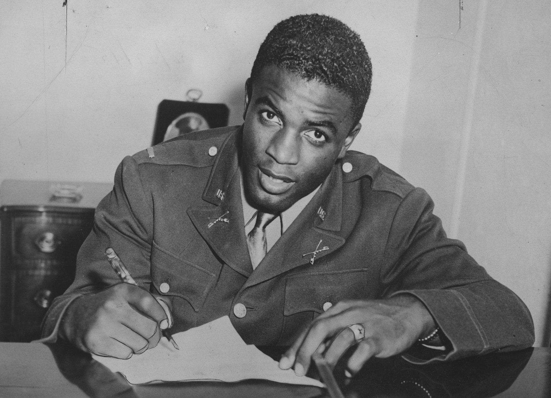 Jackie Robinson, signing paperwork with the Brooklyn Dodgers in 1945, opened the door for other Black players. Despite years of advancement, the number of Blacks in the MLB has  declined in recent decades. (Photo courtesy of Afro American Newspapers/Gado/Getty Images)

