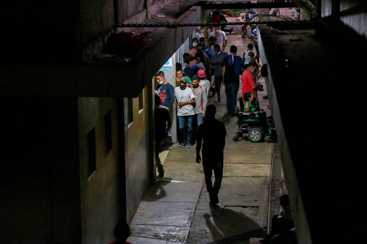 Migrants staying at Jesús el Buen Pastor, a migrant shelter in Tapachula, Mexico, line up for a free meal of black beans and tortillas on March 8, 2022. Guests are not allowed to bring food or drinks into the shelter and can’t take meals to go. Although migrants here have a roof, free meals and a mat or bed to sleep on, they must follow certain rules to stay. (Photo by Jennifer Sawhney/Cronkite Borderlands Project)
