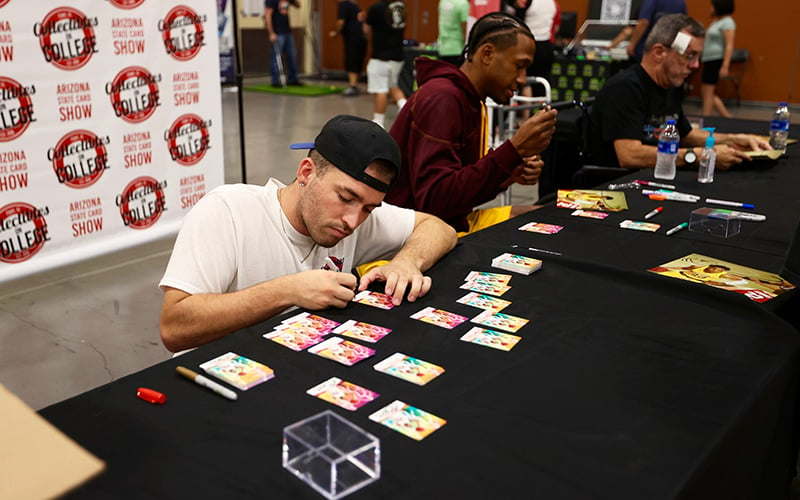 Collectibles on College founder and owner Cole McAuliff organizes the gift bags for card dealers Sunday at the end of the Arizona State Card Show. Thee gift bags included an autographed card from Arizona State junior forward Marcus Bagley. (Photo by Brooklyn Hall/ Cronkite News)