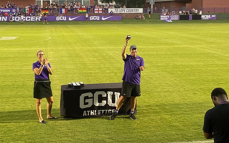 GCU women's soccer head coach Chris Cissell shows his 2021 WAC Championship ring to a program-record crowd of 3,241 fans at GCU Stadium before GCU's 1-0 win over Arizona on Thursday. (Photo by Nicholas Hodell/Cronkite News)
