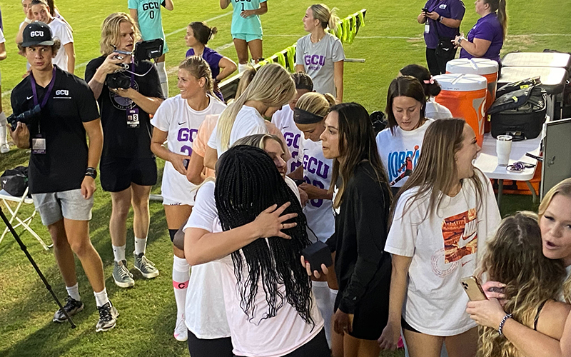 Members of the 2021 GCU women's soccer team greet each other on the sidelines after receiving their 2021 WAC Championship rings. (Photo by Nicholas Hodell/Cronkite News)