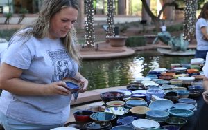 Melissa Kelsey, president of the Arizona Clay Association, helps volunteers set up and sell handcrafted bowls for Waste Not’s Empty Bowls event on Oct. 14 at the Arizona Center in downtown Phoenix. (Photo by Scianna Garcia/Cronkite News)