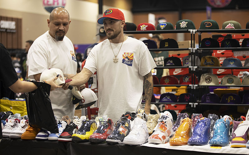 Lost Solez owners, Vida Martinez and Danny Fader, show off a variety of their collection to potential buyers at Sneaker Con. (Photo by Brooklyn Hall/Cronkite News)