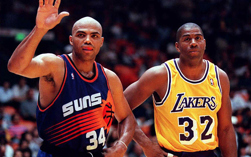Charles Barkley, left, arrived in Phoenix just as the Suns were rebranding the team. In the Sunburst jersey’s debut, Barkley scored 37 points. (Photo by Vince Bucci/AFP via Getty Images)