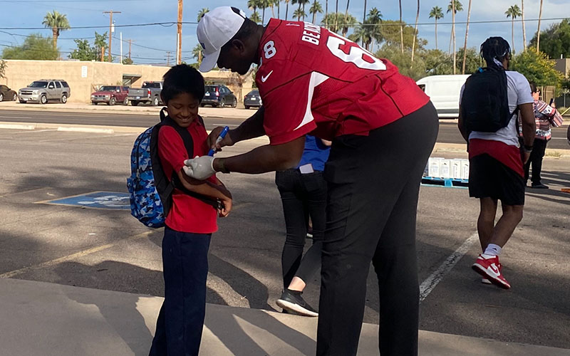 Kelvin Beachum signs a student's jersey during Verizon's Gridiron Giving Challenge at the Eisenhower Center for Innovation. (Photo by Nikash Nath/Cronkite News)