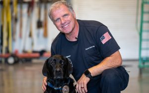 Gilbert fire investigator David Zehring poses with Zeta, an accelerant-detection canine for the ATF. Zehring is the only person who's allowed to handle Zeta during arson investigations. (Photo by Samantha Chow/Cronkite News)