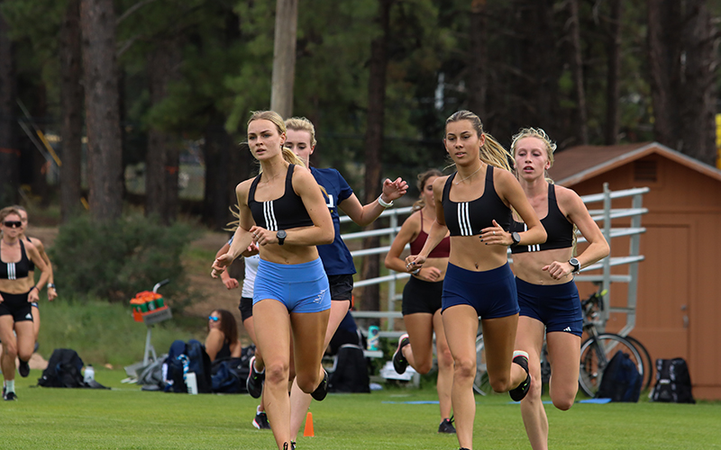 Northern Arizona cross country and track runners Nikita and Keira Moore run alongside their teammates in a practice in Flagstaff. (Photo courtesy of Northern Arizona Athletics)