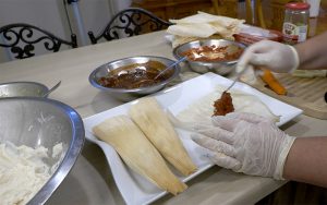 Imelda prepara el tamal “Harmony”, uno de sus famosos tamales con espinaca orgánica y queso crema. (Foto de Jimena Vera/Cronkite Noticias)