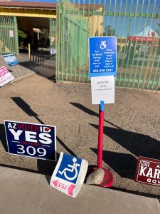 Accessibility and curbside voting signs outside polling places help voters with disabilities cast their ballots. This sign indicates the service outside a polling place in Guadalupe. (Photo by JaMirah Borden/Special for Cronkite News)