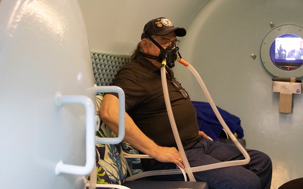 Gordon Brown demonstrates how he has used the hyperbaric chamber at HBOT of Arizona in Cave Creek to help with his traumatic brain injury Photo taken Sept. 13, 2022. (Photo by Sophie Oppfelt/Cronkite News)