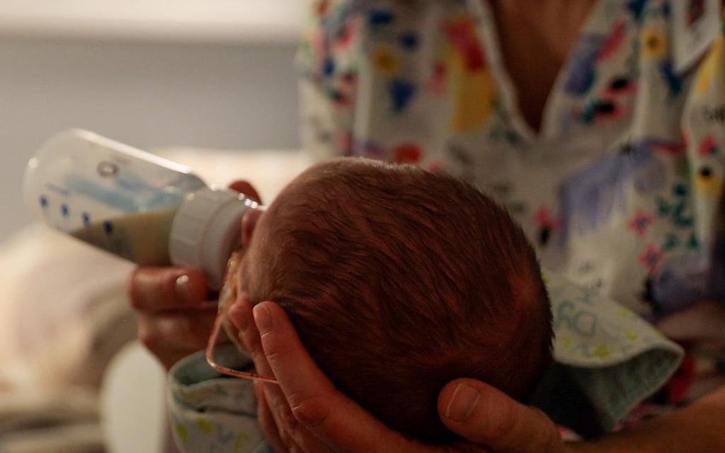 A staff member at Hushabye Nursery in Phoenix feeds one of the babies on Nov. 8, 2022. Infants brought to the nursery are withdrawing from drugs they were exposed to before birth – opioids, in particular. Across the country, cases of neonatal abstinence syndrome increased 82% from 2010 to 2017. That means that in the U.S., a baby is diagnosed with NAS every 19 minutes. (Photo by Laura Bargfeld/Cronkite News)