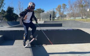 Coco Atama, who is blind, uses his cane to alert him to a dropoff as he flip his skateboard back in this photo taken Jan. 26, 2023 in a skate park in the Encino section of Los Angeles. (Photo by Ayana Hamilton/Cronkite News)