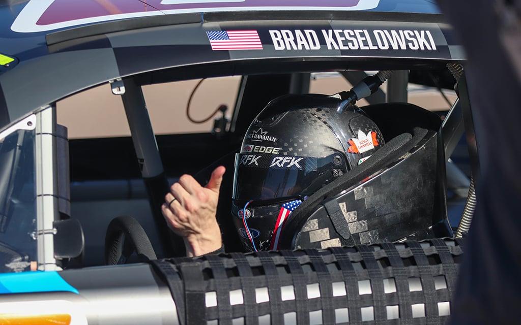 Brad Keslowski gives a thumbs up through the window of his race car.