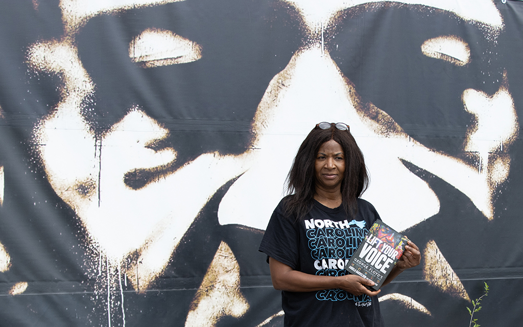 Angela Harrelson poses for a portrait with a copy of her recently published book, Lift Your Voice, Saturday, July 9, 2022, at George Floyd Square in Minneapolis, Minnesota. Harrleson visits the square — where her nephew, George Floyd, was killed by a Minneapolis police officer — every Saturday. (Photo by Diannie Chavez/News21)