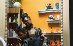 LeKyndra Ouedrago twists a child's hair in her hair salon.