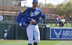 Chris Taylor waves to the camera while walking on a baseball field.
