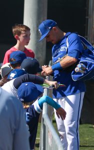 Nicky Lopez of the Kansas City Royals writes signatures for children.