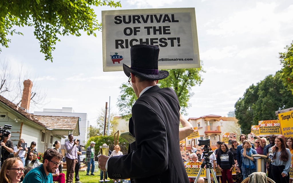 People opposed to the Arizona Coyotes arena and entertainment district proposal dress up to mock who they say are billionaire proponents of propositions 301, 302, and 303 on March 20, 2023, in Tempe. (Photo by Drake Presto/Cronkite News)