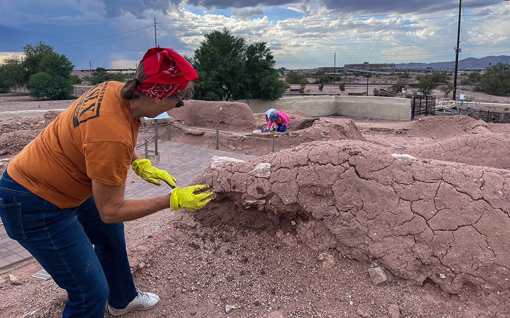 Volunteers throw mud to preserve an ancient artifact at Pueblo Grande Museum Archaeological Park