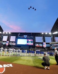 Phoenix police officer Tyler Moldovan, with the help of his wife Chelsea, threw out the ceremonial first pitch Thursday in the Arizona Diamondbacks' home opener against the Los Angeles Dodgers. (Photo by Norm Hall/Getty Images)