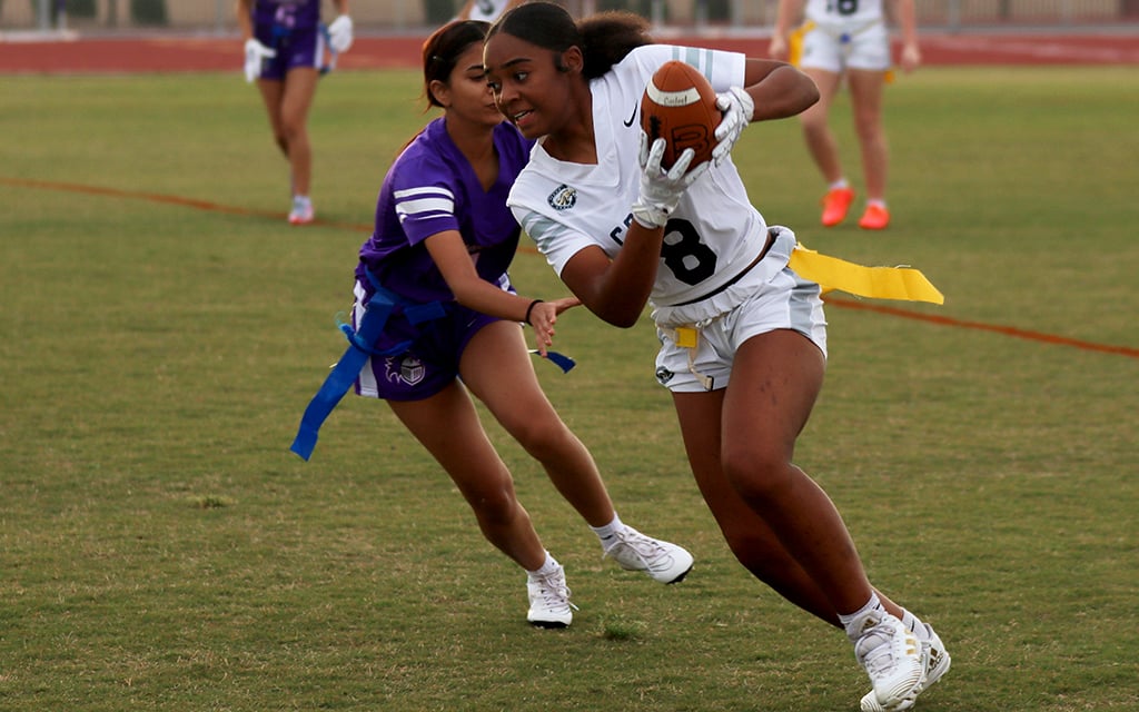 Casteel High School wide receiver Khali Boller runs along the sideline past an Arizona College Prep defender. Girls flag football will become an AIA-sanctioned sports in the fall. (Photo by Aidan Richmond/Cronkite News)