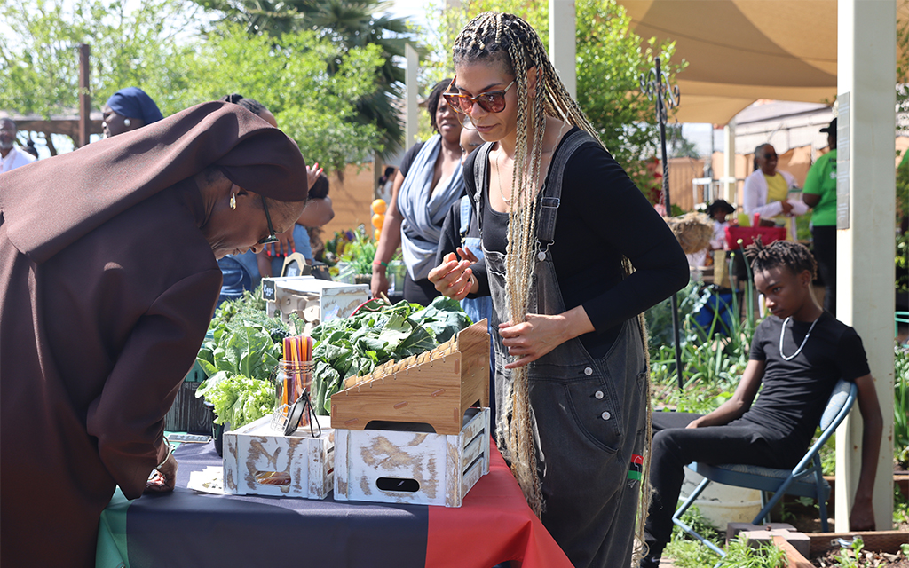 Ophelia Muhammad, left, talks to Rachel Opio about her produce at the Heart and Soil People’s Garden in Phoenix on March 18, 2023. (Photo by Lauren Kobley/Cronkite News)