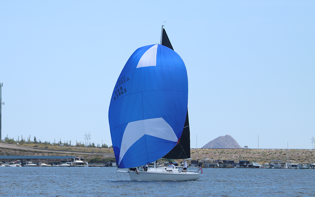 Dreamline deploys its large blue sail, known as a spinnaker, to help increase speed Saturday at the 2023 Tall Cactus Regatta. (Photo by Brevin Monroe/Cronkite News)