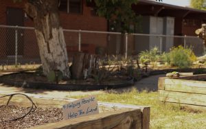 One of the many positive messages featured in the planters at the TigerMountain Foundation community gardens on April 25, 2023. This message - a sign that says, "Helping people help the land." (Photo by Logan Camden/Cronkite News)