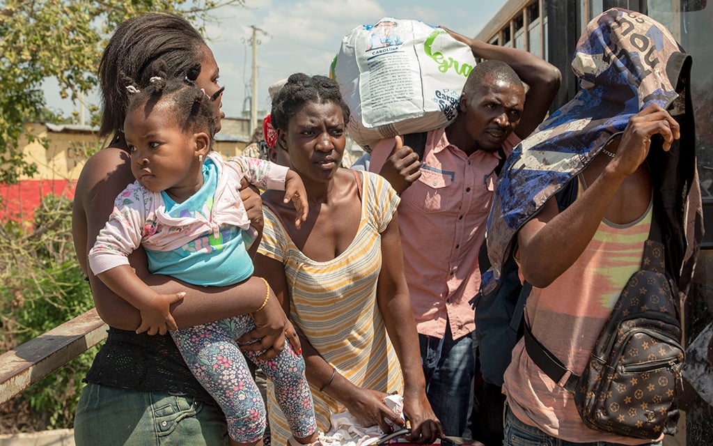 A group of Haitians, including a young girl, are deported to Haiti at the border gates in Dajabón, Dominican Republic, on March 4, 2023. (Photo by Roxanne De La Rosa/Cronkite Borderlands Project)
