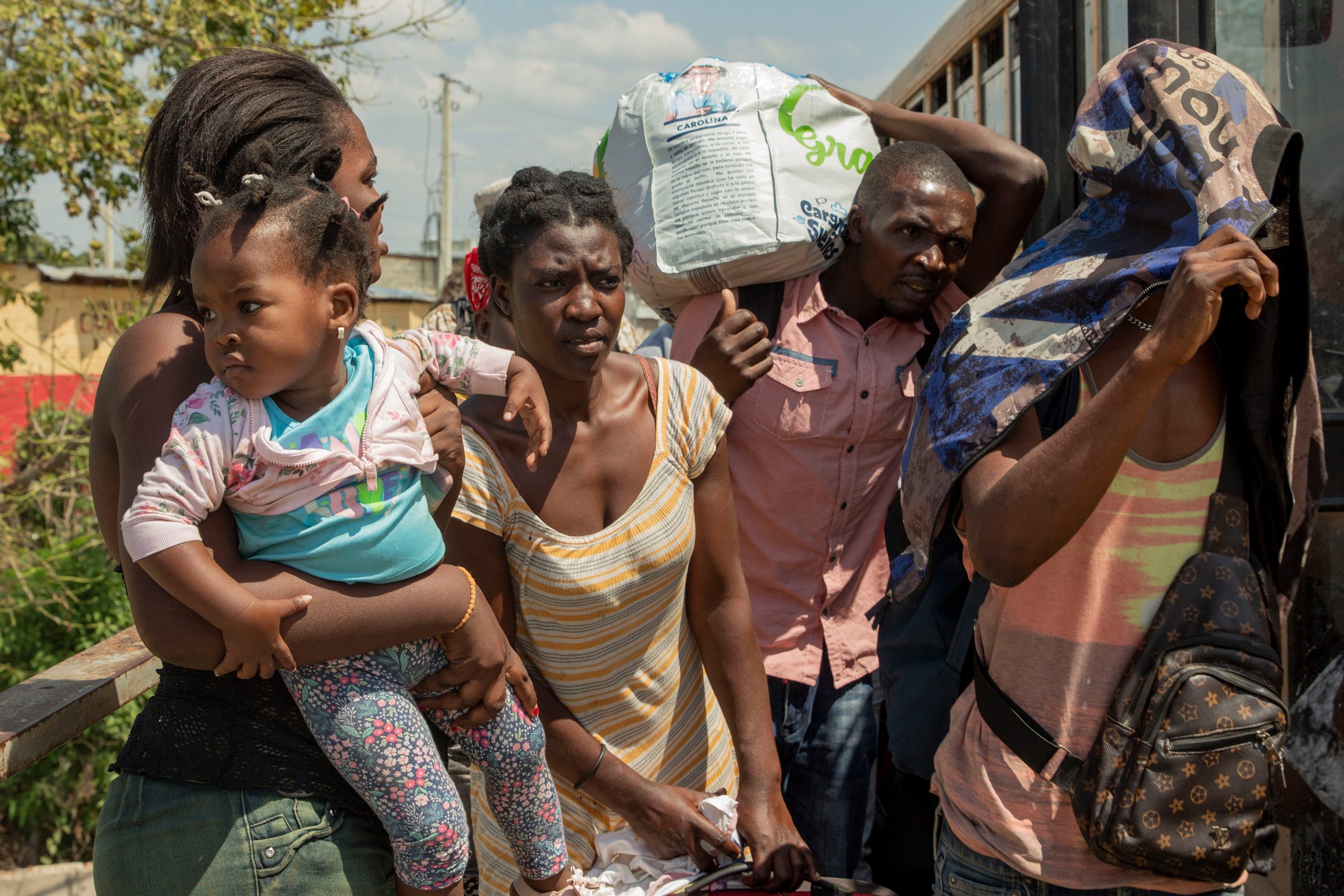 A group of Haitians, including a young girl, are deported to Haiti at the border gates in Dajabón, Dominican Republic, on March 4, 2023. (Photo by Roxanne De La Rosa/Cronkite Borderlands Project)
