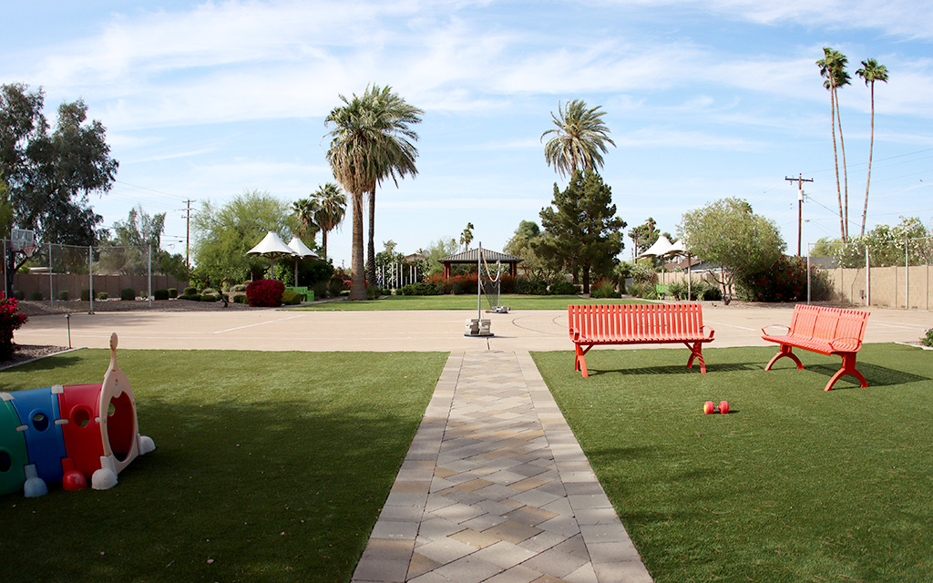 The backyard of the Girls Ranch residential facility is an open space for teens and their children to use. The backyard features multiple sitting areas, trees and a rock garden. Photo taken April 19, 2023. (Photo by Izabella Hernandez/Cronkite News)