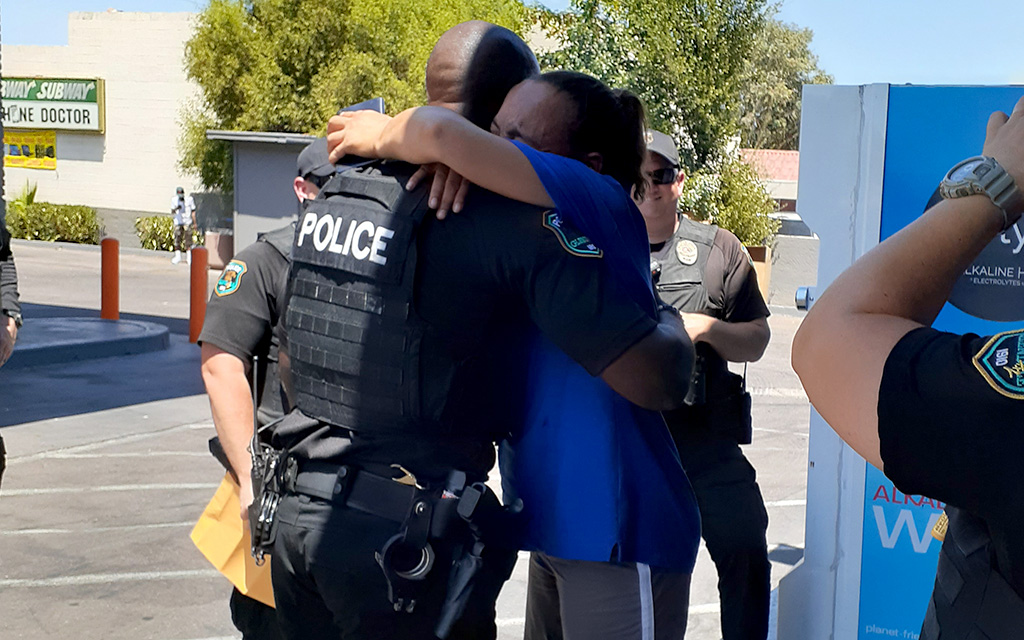 A Glendale police officer hugs an Angels on Patrol client after he and other officers collected money for her after her purse was stolen. (Photo courtesy of Angels on Patrol)