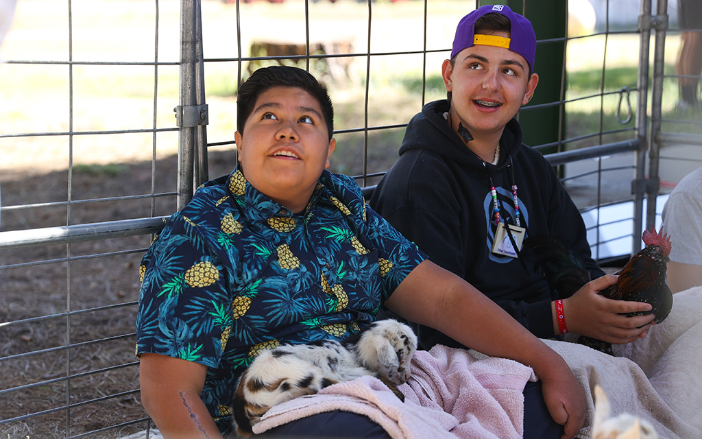 Campers Jose Noriega, left, and Ethan Sauerhoefer handle animals during a demonstration at Camp Not-A-Wheeze in Heber, Arizona. (Photo by Joey Plishka/Cronkite News)
