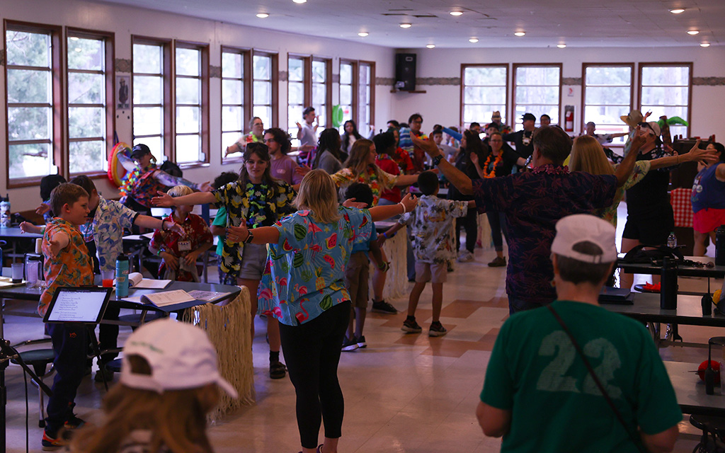 Campers and leaders at Camp Not-A-Wheeze sing and dance in the cafeteria during lunch. Camp Not-A-Wheeze is a summer camp experience for kids with asthma held each year in Heber, Arizona. (Photo by Joey Plishka/Cronkite News)