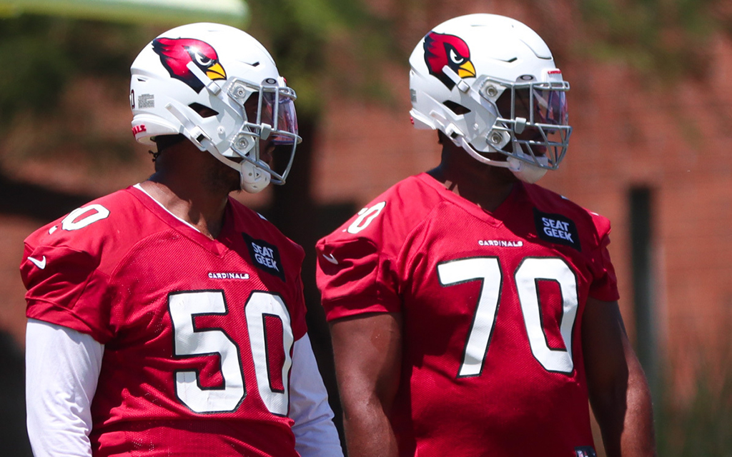 Arizona Cardinals offensive linemen Julién Davenport, left, and Paris Johnson Jr. observe drills during Wednesday's OTAs. Selected sixth overall in the 2023 NFL Draft, Johnson is projected to start this season. (Photo by Bobby Murphy/Cronkite News)