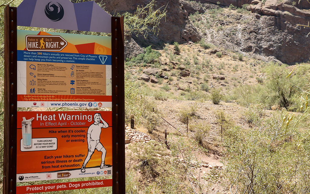 “Take a Hike, Do it Right” signs warn visitors of the dangers while hiking in hot conditions. The city limits hiking on some popular trails from 11 a.m. to 5 p.m. on days the National Weather Service issues an excessive heat warning. (Photo By Evelin Ruelas/Cronkite News)