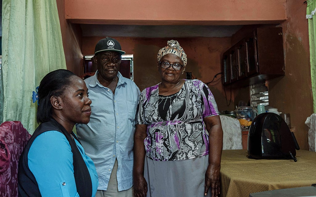 Rosa Boye sits as her parents, Emilio and Linda Boye, pose in their home in Santo Domingo’s Bienvenido neighborhood on March 7, 2023. Both Rosa and Emilio are coordinators for the Sugarcane Workers’ Union, and Emilio worked over four decades as a sugar worker. (Photo by John Leos/Cronkite Borderlands Project)